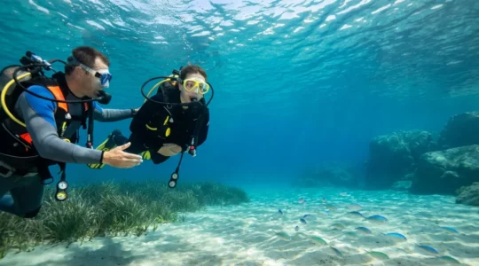 Plongeur débutant découvrant les fonds marins corses avec son moniteur dans une eau cristalline