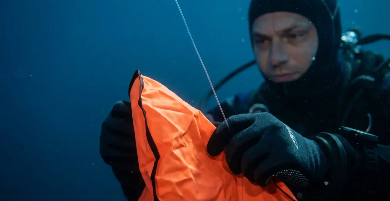Plongeur déployant un parachute de signalisation orange en plein courant, vue sous-marine détaillée