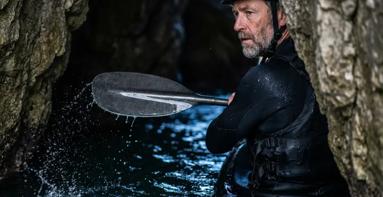 Kayakiste utilisant une technique de pagaie latérale dans une grotte marine étroite avec ressac