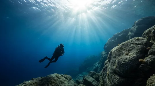 Photographe sous-marin captant les rayons de lumière à travers les eaux cristallines de Corse