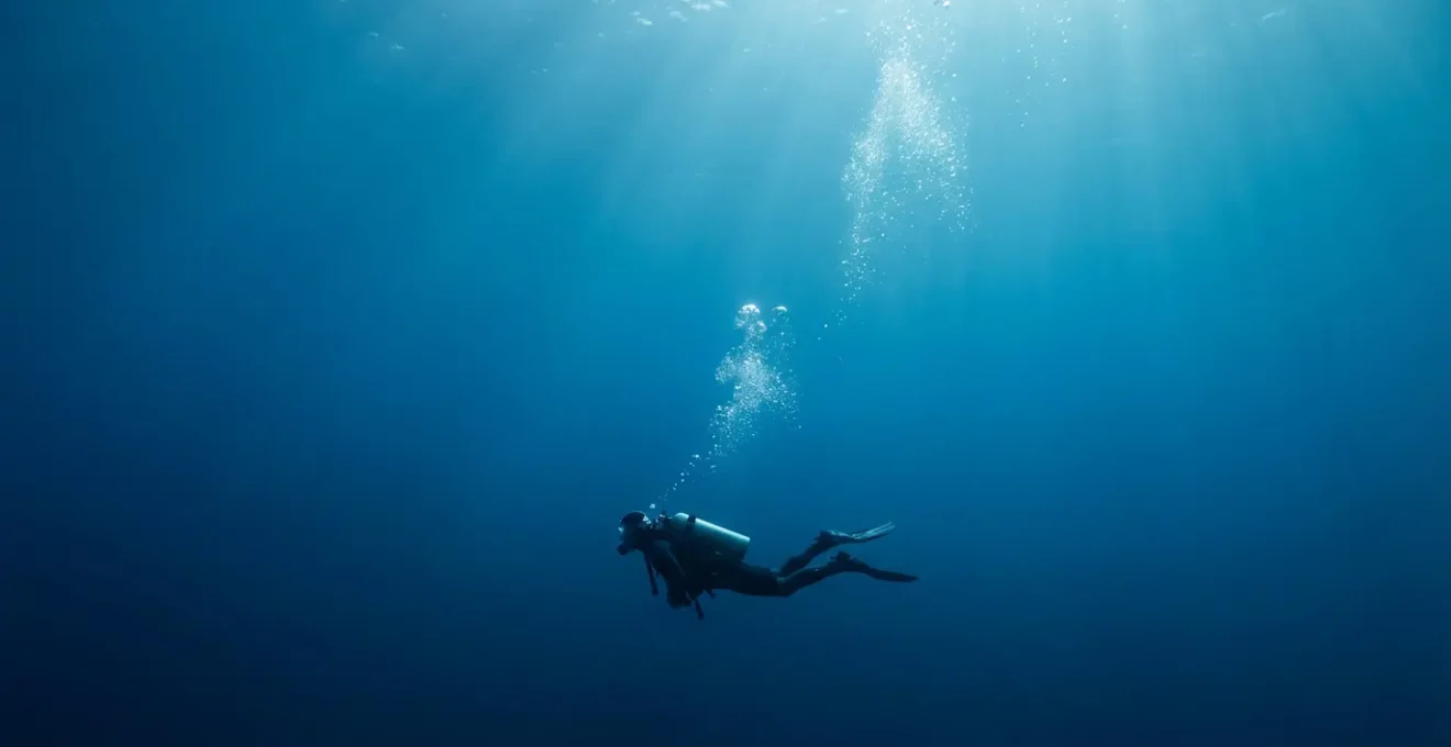 Plongeur sous-marin en train d'effectuer un palier de décompression avec des bulles d'air s'échappant de son détendeur